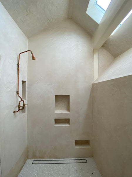 Copper pipe shower set in a brilliant bathroom design, bright and simple, natural and rough finishes.